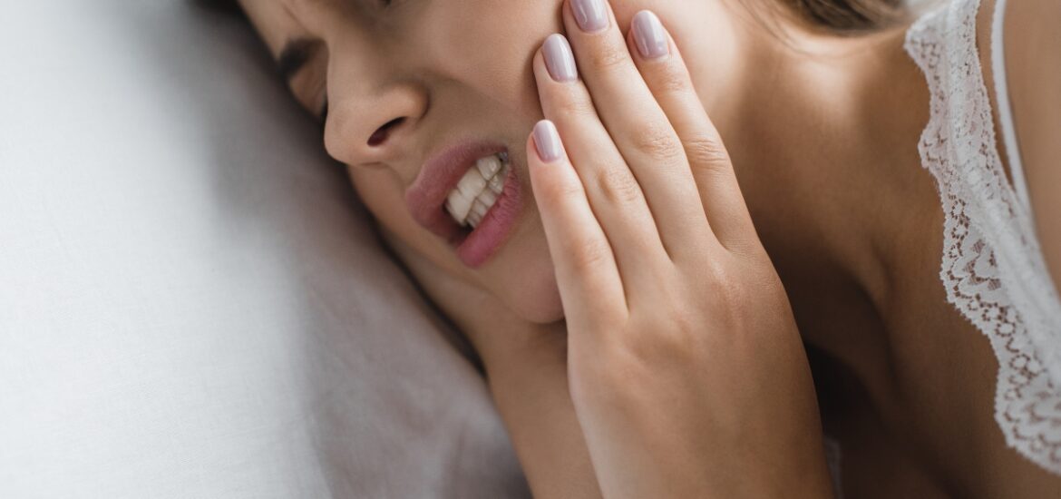 Woman experiencing tooth pain during a dental emergency