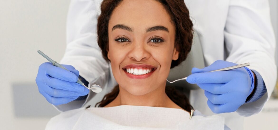 Smiling adult woman in dental chair with healthy teeth during checkup